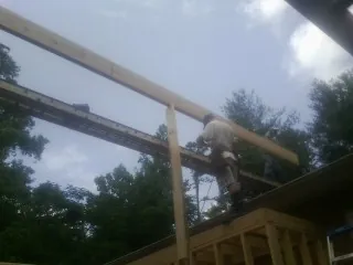 Carpenter setting a ridge beam over a new addition frame — Ice Dam Removal by Roofing Brothers in West Chesterfield