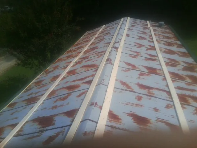 Rusted metal roof panels with new wood purlins before replacement — Storm Damage Roof Repair in West Chesterfield by Roofing Brothers